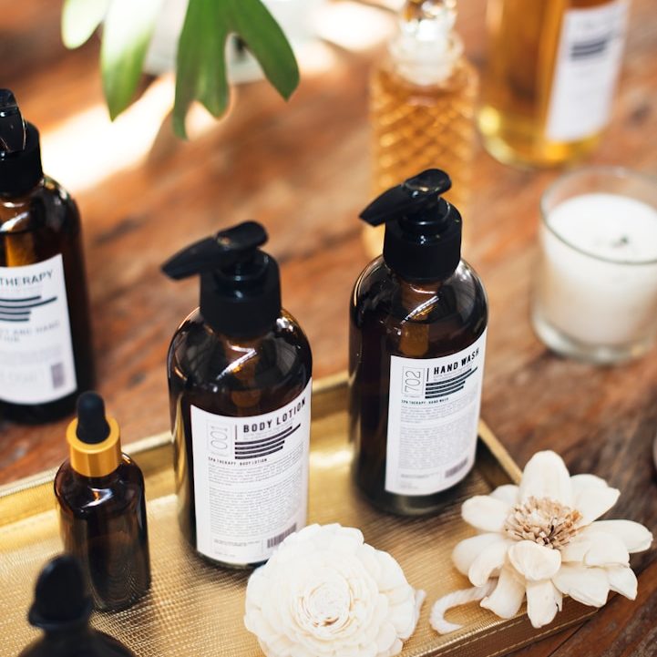 Ätherische Ölfläschchen und Blüten als Beispiel für natürliche Aromaanwendungen und Pflegeprodukte im Alltag